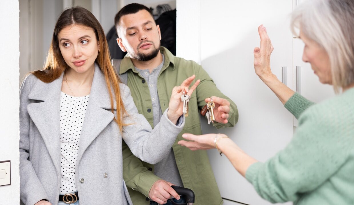 Dissatisfied owner receiving keys from married couple tenants