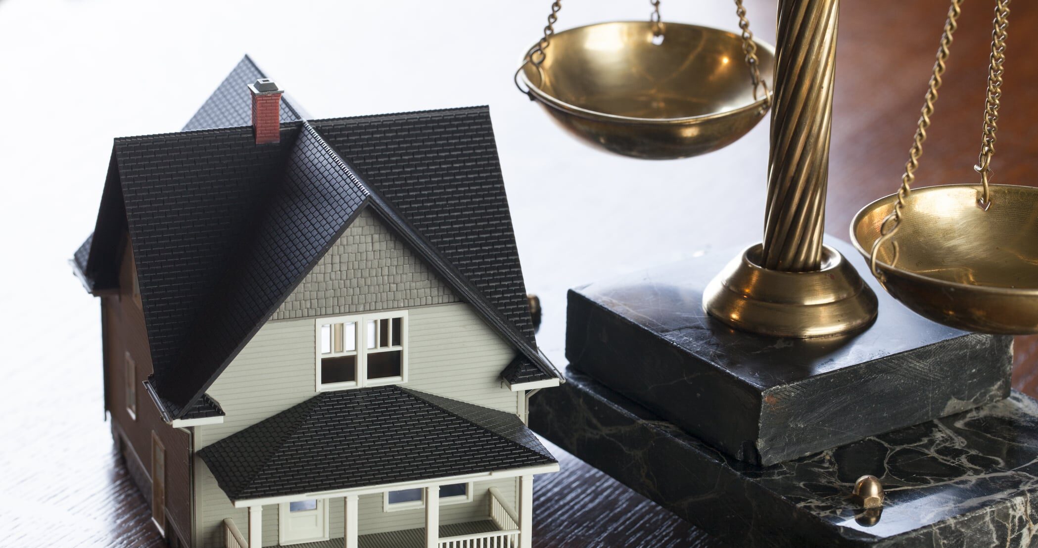 House and Scales of Justice on wood table